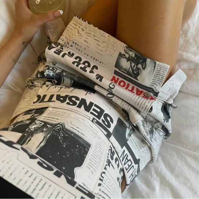 Clarissa - Off-the-shoulder playsuit with newspaper print