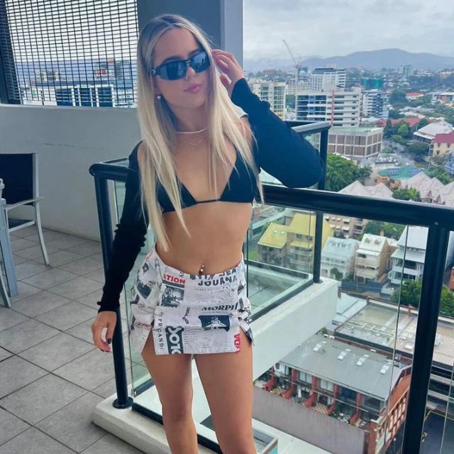 Clarissa - Off-the-shoulder playsuit with newspaper print
