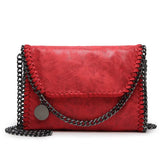 Isabel - Suede clutch with chain embellishment